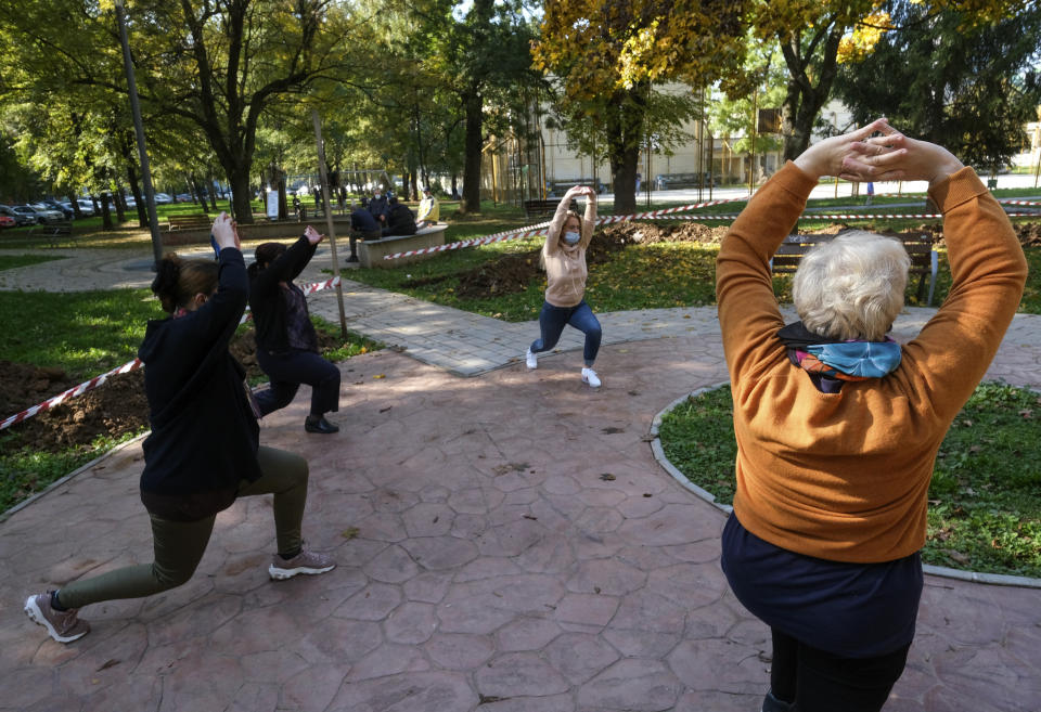 Women exercise during a therapy session in a park in Sarajevo, Bosnia Monday, Oct. 26, 2020. As coronavirus cases surge in Bosnia, the pandemic is heaping new trouble on an impoverished nation that has never recovered economically or psychologically from a war in the 1990s. Bosnian health authorities estimate that nearly half of the Balkan nation’s nearly 3.5 million people have suffered some degree of trauma resulting from the war. (AP Photo/Kemal Softic)