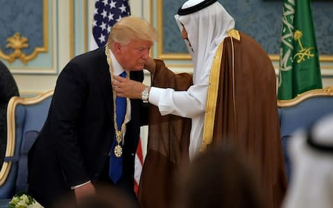 US President Donald Trump receives the Order of Abdulaziz al-Saud medal from Saudi Arabia's King Salman bin Abdulaziz al-Saud at the Saudi Royal Court in Riyadh on May 20, 2017 - Credit: AFP