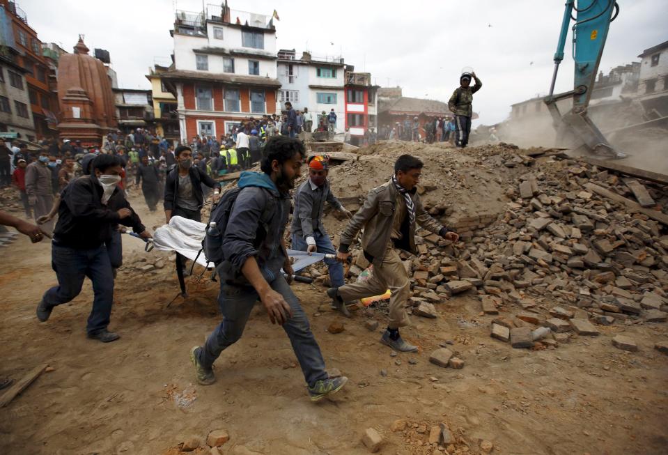 People carry the body of a victim on a stretcher, which was trapped in the debris after an earthquake hit, in Kathmandu, Nepal