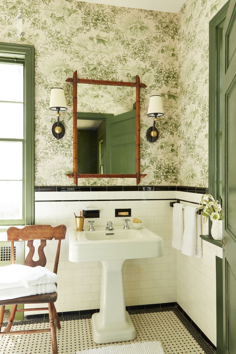 bathroom with green floral wallpaper and white tile wainscoting with black tile trim