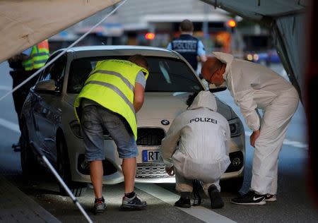 Police forensic experts work on a car where a 21-year-old Syrian refugee killed a woman with a machete and injured two other people in the city of Reutlingen, Germany July 24, 2016. REUTERS/Vincent Kessler