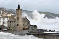 Waves crash on the harbour at Porthleven, Cornwall, as winds battered the UK. The Met Office issued weather warnings across south west England, the Midlands, the South East and Wales.