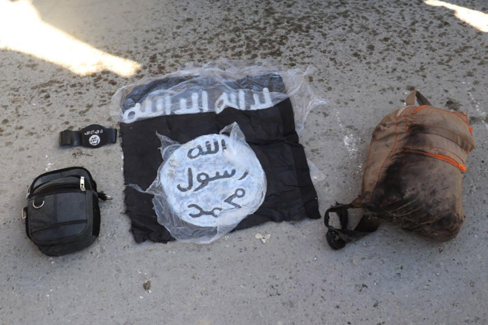 This photo provided by the Kurdish-led Syrian Democratic Forces shows the flag and bags of Islamic State group fighters who were arrested by the Kurdish-led Syrian Democratic Forces after they attacked Gweiran Prison, in Hassakeh, northeast Syria, Friday, Jan. 21, 2022. IS attacks have been on the rise in recent months in both Iraq and neighboring Syria, where the group once set up a self-styled Islamic caliphate before being defeated by an international coalition. (Kurdish-led Syrian Democratic Forces, via AP)