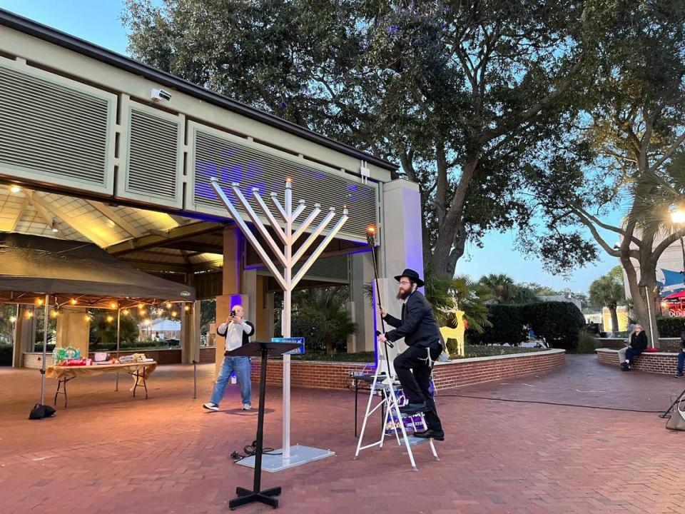 Rabbi Mendel steps down from the ladder after lighting the menorah Thursday, the first day of Hanukkah, the Jewish holiday that lasts for eight nights. The menorah lighting was at Waterfront Park in Beaufort.
