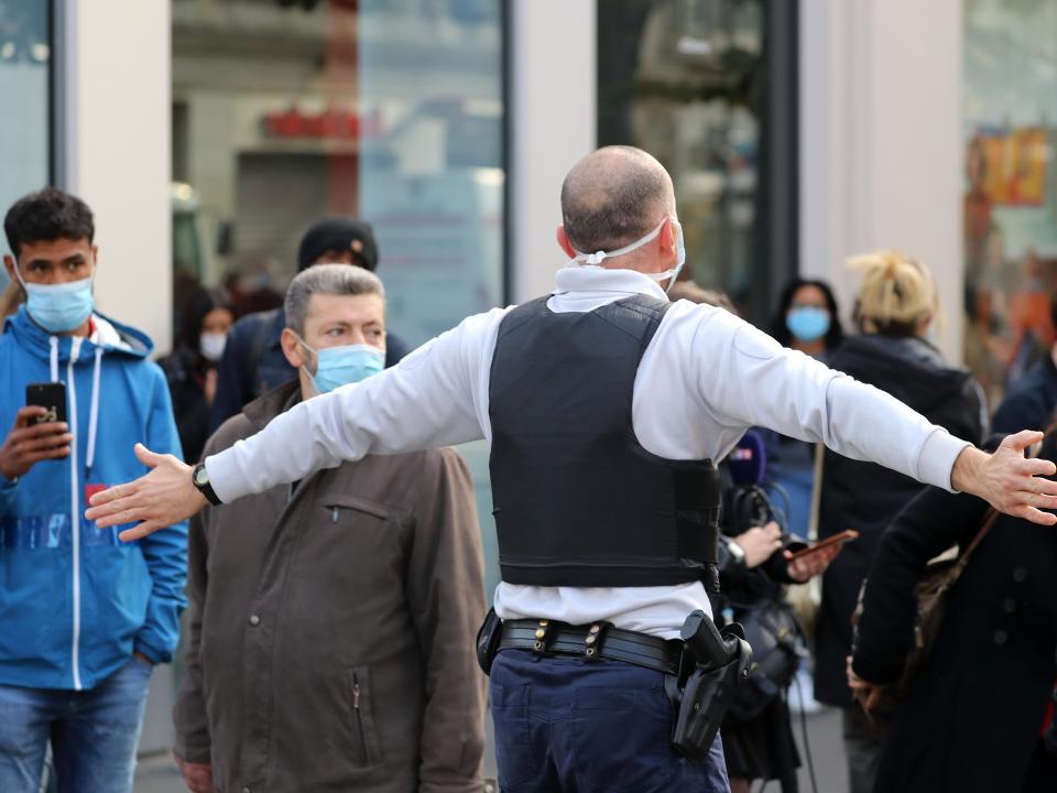 A French policeman pushes bystanders back off the street after a knife attack in Nice (AFP via Getty Images)