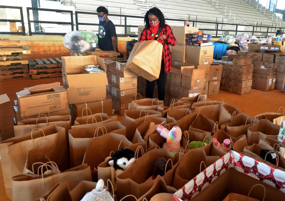 Volunteers Sharon Cooley and son Jordan Cooley fill gift bags to be handed out at the 39th annual J.P. Hall Christmas Party in 2020. Hundreds of gifts were given to children through car windows as their families waited in a drive-thru line.