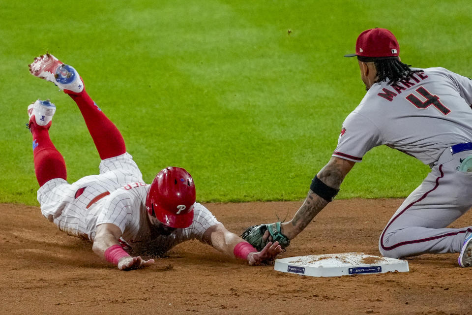 Philadelphia Phillies' Kyle Schwarber is tagged out stealing by Arizona Diamondbacks second baseman Ketel Marte during the eighth inning in Game 6 of the baseball NL Championship Series in Philadelphia Monday, Oct. 23, 2023. (AP Photo/Matt Rourke)