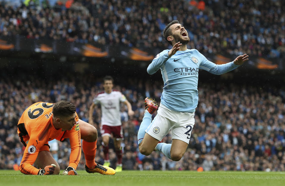 Manchester City’s Bernardo Silva, right, is fouled by Burnley goalkeeper Nick Pope resulting in a penalty