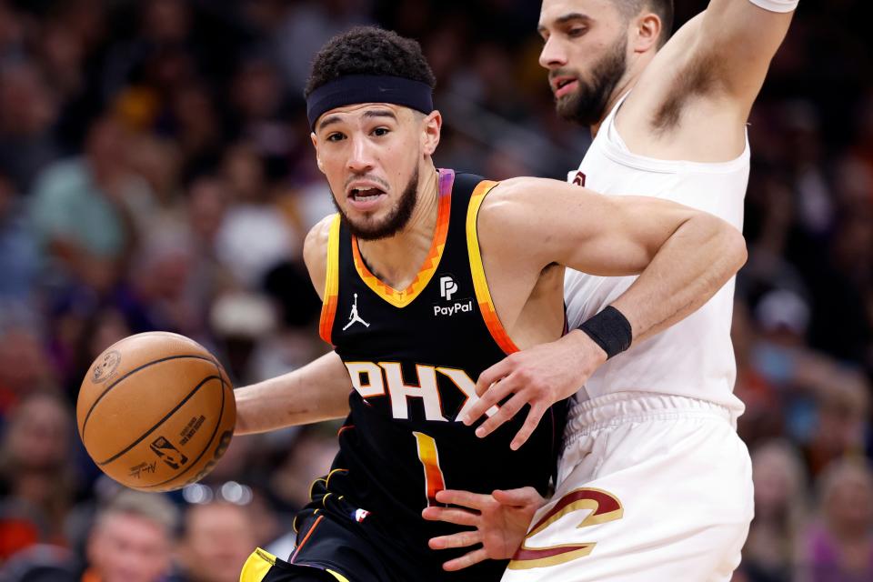 Devin Booker #1 of the Phoenix Suns drives to the basket against Max Strus #1 of the Cleveland Cavaliers during the second half at Footprint Center on April 03, 2024 in Phoenix, Arizona.