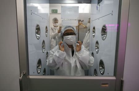 A visitor goes through a decontamination process before a tour of Panasonic's first indoor vegetable farm at their factory in Singapore July 31, 2014. REUTERS/Edgar Su