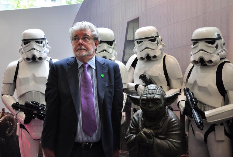 George Lucas poses with Stormtroopers and Yoda at the opening of Lucasfilms' new animation production facility, the Sandcrawler in Singapore on January 16, 2014