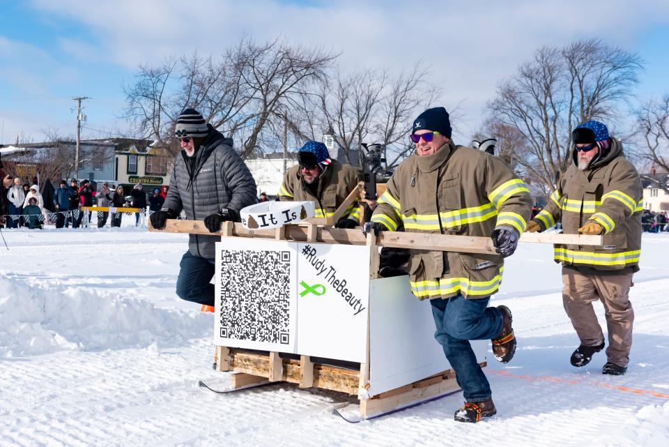 Team "Rudy the Beauty" crosses the finish line during the annual Outhouse Races as part of the Mackinaw City Winterfest in the Shepler's Ferry parking lot on Saturday, Jan. 20, 2024.