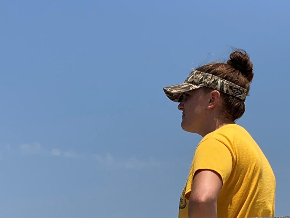 Chelsea Coleman, a volunteer who came out to help look for the seven missing people who were aboard the Seacor Power when it capsized on April 13, scans the horizon on Thursday, April 30, 2021, along the Louisiana coast. Volunteers have been searching by air and boat for any sign of those still missing. (AP Photo/Rebecca Santana)