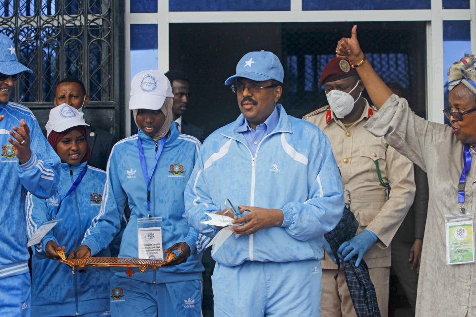 FILE - In this Tuesday, June 30, 2020, file photo, Somalia's President Mohamed Abdullahi Mohamed, center, prepares to cut the ribbon for the reopening of the stadium in Mogadishu, Somalia. As Somalia marks three decades since a dictator fell and chaos engulfed the country, the government is set to hold a troubled national election but two regional states are refusing to take part in the vote to elect Somalia's president and time is running out before the Feb. 8 date on which mandates expire. (AP Photo/Farah Abdi Warsameh, File)
