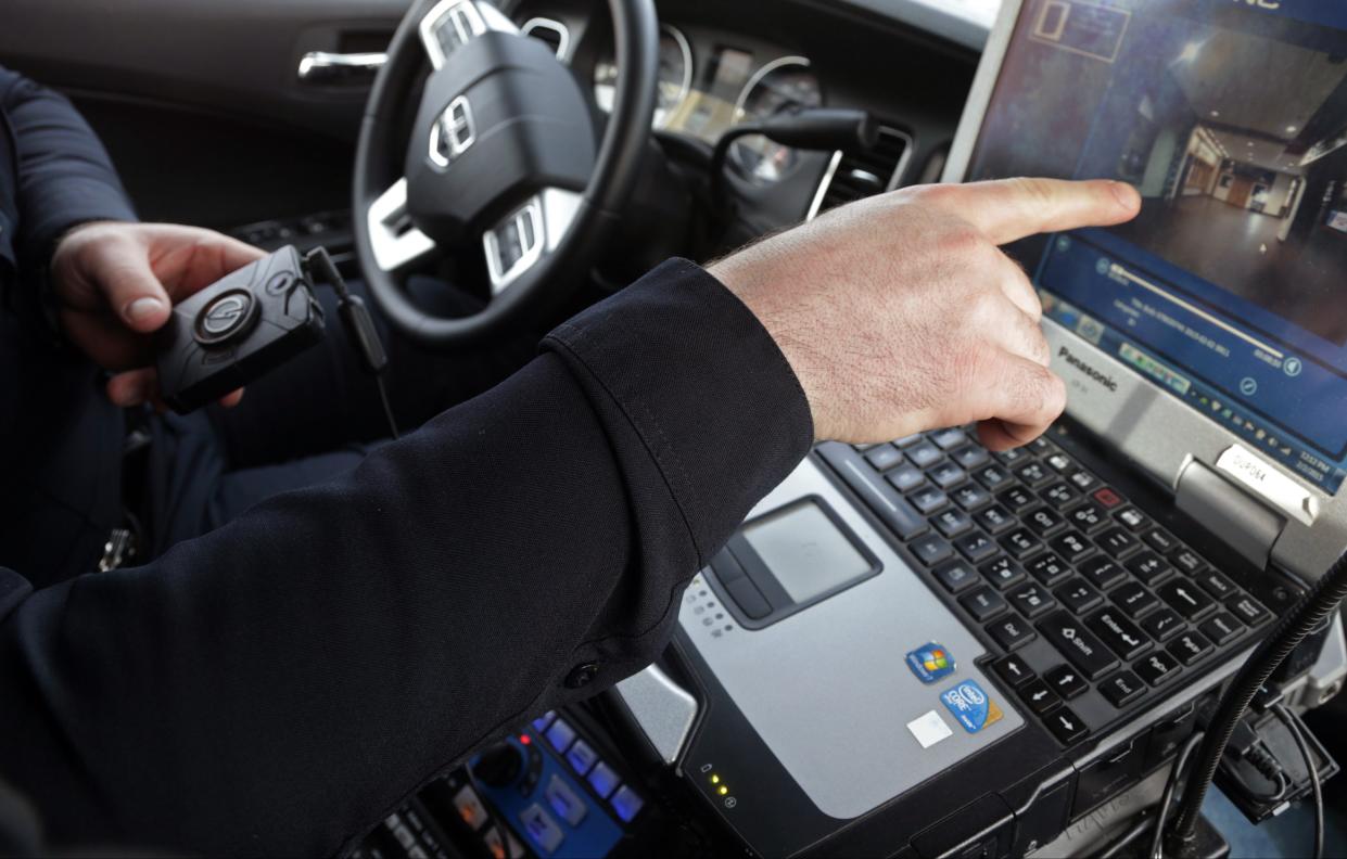 A Minnesota police officer points to an image on his computer that was made by the body camera, left, that he was wearing during a shoplifting investigation. Law enforcement agencies in central Wisconsin say an increase in open records requests for video from police officer body cameras and squad car cameras has created a backlog in some departments as they must review all footage before it is released and redact or blur out some information.