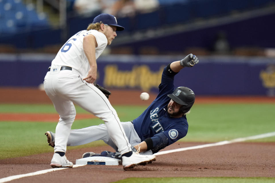 Seattle Mariners' Eugenio Suarez slides ito third base ahead of the throw to Tampa Bay Rays third baseman Taylor Walls with an RBI triple during the first inning of a baseball game Thursday, April 28, 2022, in St. Petersburg, Fla. (AP Photo/Chris O'Meara)