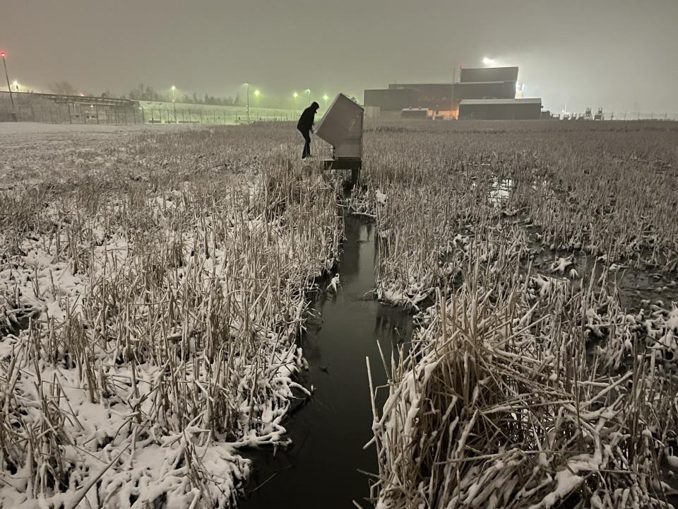 Owen Stefaniak, a scientist with the U.S. Geological Survey, retrieves surface water samples near the Air Guard 128th Air Refueling Wing base, 1919 E Grange Ave., during an overnight winter storm. A recent study shows that airplane deicers are polluting waterways near Milwaukee Mitchell International Airport with phosphorus.