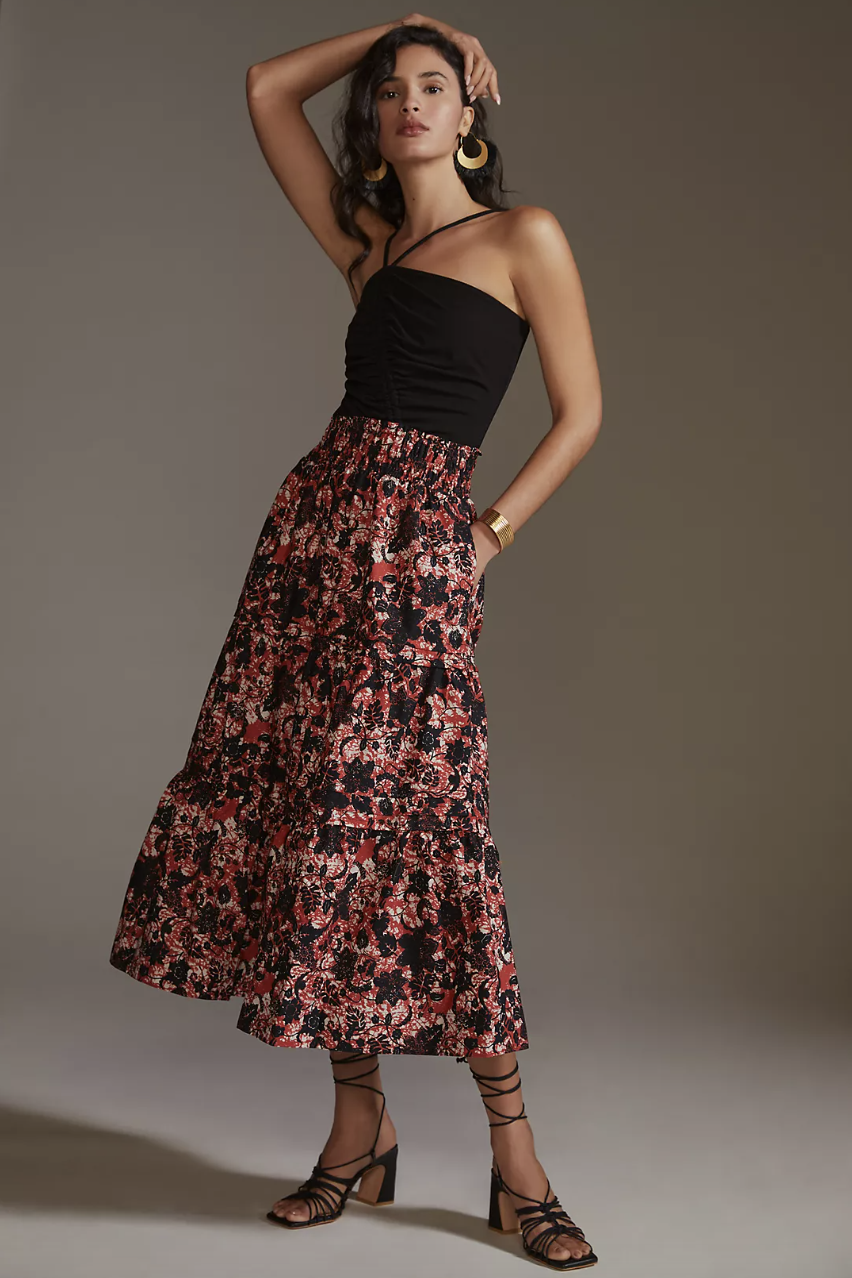 model in black tank top, black strappy sandals, and printed The Somerset Maxi Skirt in Red Motif (Photo via Anthropologie)