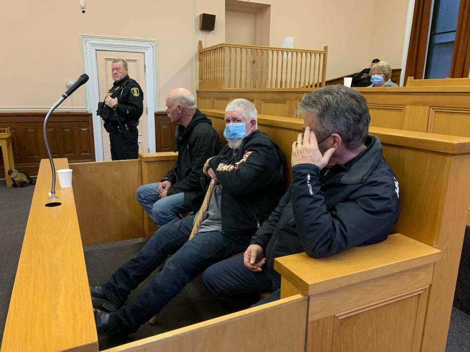 From left, Wayne Johnson, James Curran and Vince Leonard shy away from media at Supreme Court on Thursday. (CBC - image credit)