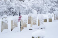 Snow covers gravestones during a winter snow storm in Doylestown, Pa., Tuesday, Feb. 13, 2024. (AP Photo/Matt Rourke)