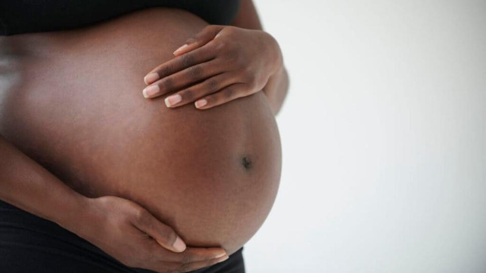 pregnant Black woman holding belly theGrio.com