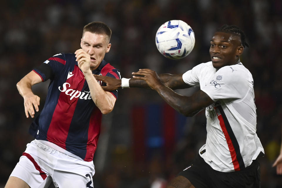 Rafael Leao (derecha) del AC Milan y Michel Aebischer del Bologna pugnan por el balón en el partido de la Serie A italiana, el lunes 21 de agosto de 2023. (Massimo Paolone/LaPresse vía AP)