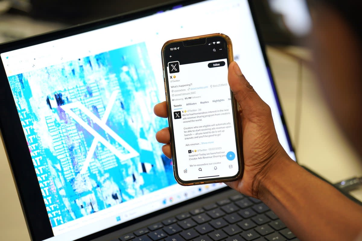 A person looks at the new logo for Twitter on an Apple iPhone in an office in London (Jonathan Brady/PA Wire)