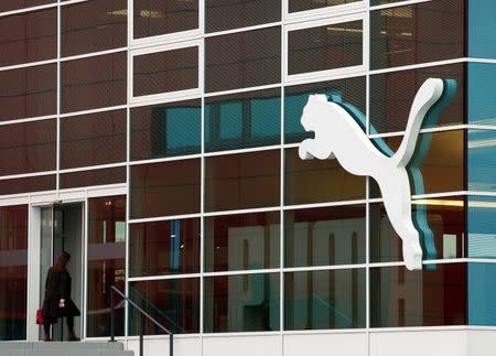 A woman enters the headquarters of German sports goods firm Puma in Herzogenaurach, Germany in this February 20, 2014 file photo. REUTERS/Michaela Rehle/Files