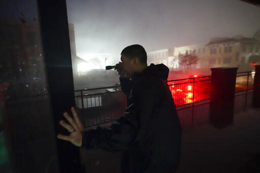 Greg Hatton, a hotel employee, surveys damage in Pensacola, Florida, in the early hours of WednesdayAP