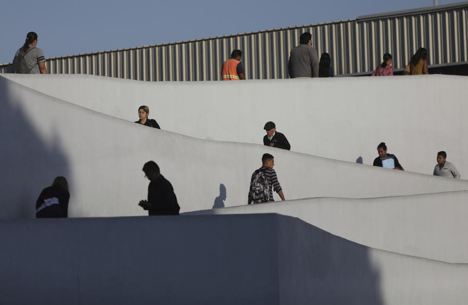 FILE - In this Friday, Sept. 13, 2019, file photo, people use the legal border crossing into the United States, on the U.S.- Mexico border in Tijuana, Mexico. In its efforts to remake the U.S. immigration system, the Trump administration has often stumbled over an obscure law that governs how administrative policies are made. Its latest test is a mammoth proposal to severely limit access to asylum, which invited nearly 80,000 public comments before the Wednesday, July 15, 2020, deadline to offer feedback. (AP Photo/Emilio Espejel, File)