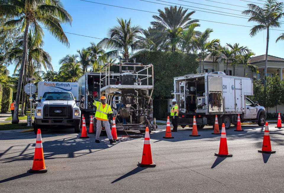 Contractors from AEGION use cones to redirect traffic in Palm Beach, Fla., as they work to reline a sewer on Jan. 17, 2023. Sewer relining or pipe relining is a trenchless sewer repair method that creates a brand new pipe directly inside the old one using an epoxy lining.