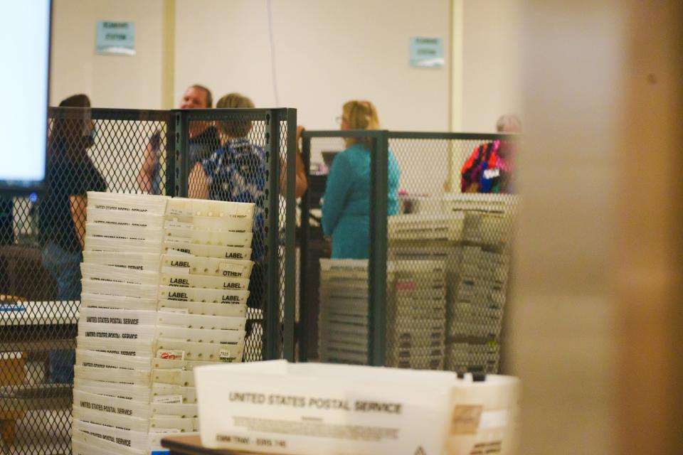 Empty United States Postal Service boxes are stacked on a cart as early mail-in ballots are counted at the Maricopa County Tabulation and Election Center on Aug. 1, 2022, in Phoenix, Ariz.