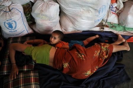 A Rohingya Hindu refugee child lays down next to its mother inside their temporary shelter at the Kutupalong Hindu refugee camp near Cox's Bazar, Bangladesh December 17, 2017. REUTERS/Marko Djurica