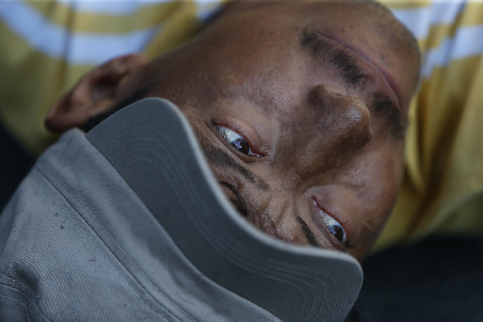 A man rests on the street after scores of Central American migrants, representing the thousands participating in a caravan trying to reach the U.S. border, undertook an hours-long march to the office of the United Nations' humans rights body in Mexico City, Thursday, Nov. 8, 2018. Members of the caravan which has stopped in Mexico City demanded buses to take them to the U.S. border, saying it is too cold and dangerous to continue walking and hitchhiking.(AP Photo/Rebecca Blackwell)