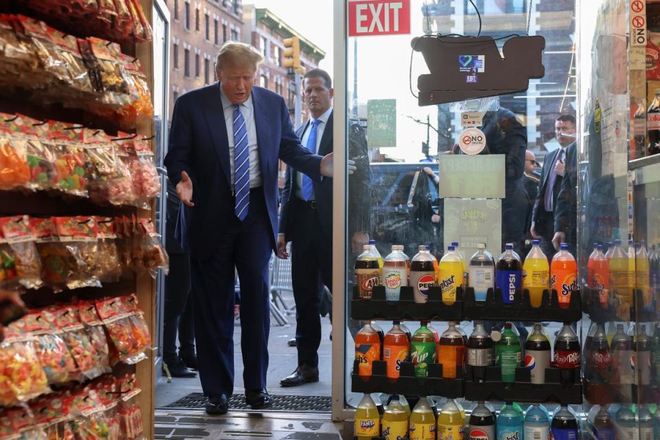 Former president Donald Trump reacts as he enters the Sanaa convenience store in Harlem on Tuesday afternoon (AP)