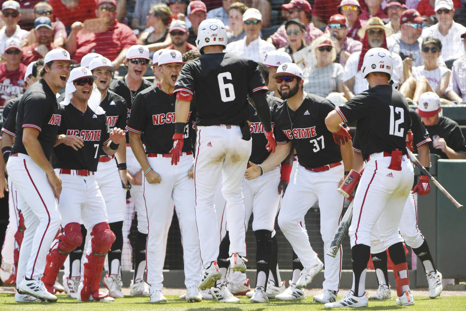 North Carolina State batter Vojtech Mensik (6) is greeted by teammates after hitting a home run against Arkansas in the fourth inning of an NCAA college baseball super regional game Saturday, June 12, 2021, in Fayetteville, Ark. (AP Photo/Michael Woods)