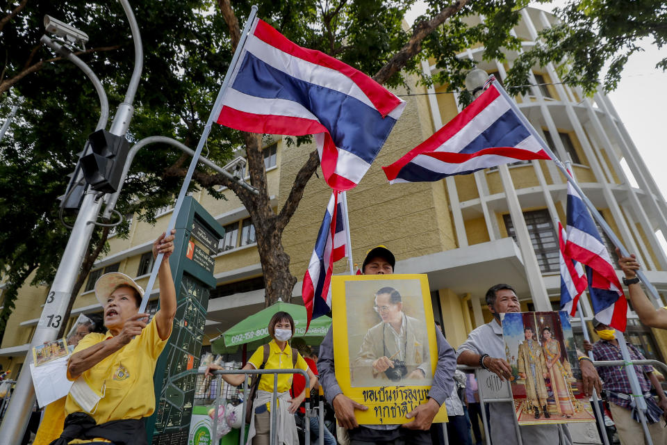 Supporters of the monarchy display images of King Maha Vajiralongkorn, Queen Suthida and late King Bhumibol Adulyadej as they gather at Democracy Monument ahead of a pro-democracy demonstration in Bangkok, Thailand, Sunday, Nov. 8, 2020. Thai royalists have recently been holding counter-demonstrations, but so far, they have lacked the numbers and enthusiasm of the pro-democracy activists. (AP Photo/Sakchai Lalit)