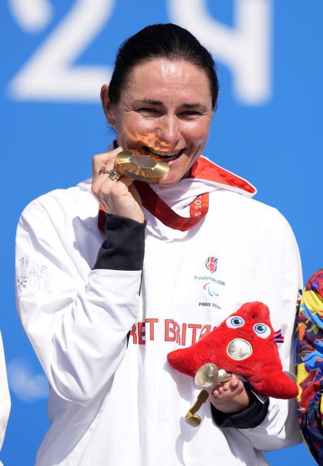 Great Britain’s Sarah Storey bites into her gold medal in celebration