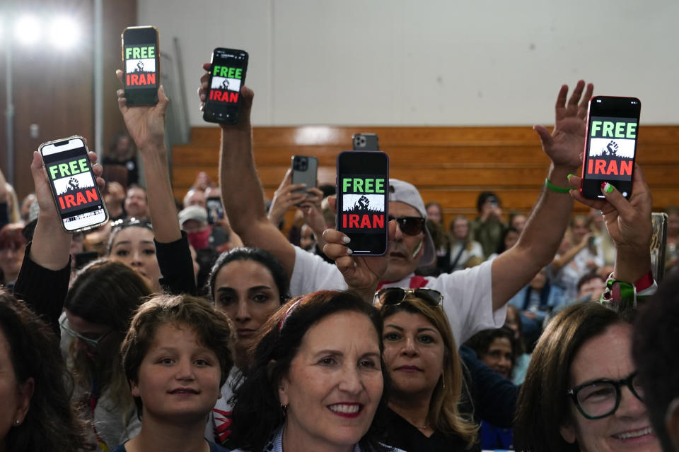 People hold up phones displaying the words 'Free Iran' as President Joe Biden speaks at a campaign event in support of Rep. Mike Levin, D-Calif., Thursday, Nov. 3, 2022, in San Diego. (AP Photo/Patrick Semansky)