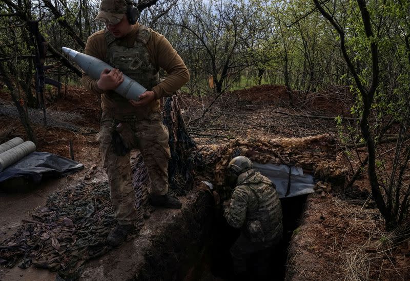 FILE PHOTO: Ukrainian service members prepare fire a howitzer D30 at a front line near the city of Bakhmut