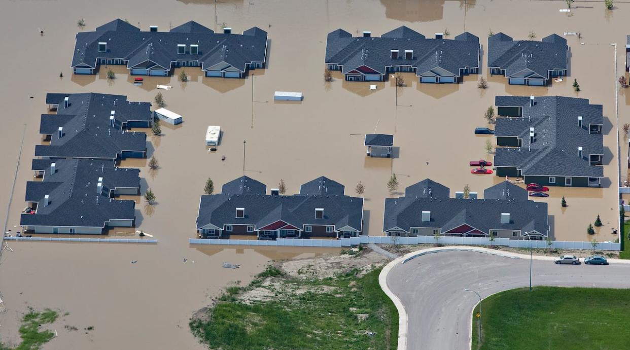Houses are surrounded by flood water in High River, Alta., south of Calgary, on June 23, 2013. (Reuters/Andy Clark - image credit)