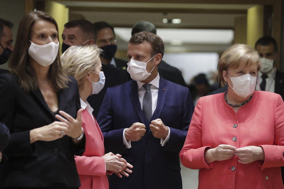 From left, Belgium's Prime Minister Sophie Wilmes, European Commission President Ursula von der Leyen, French President Emmanuel Macron and German Chancellor Angela Merkel speaks as they arrive for a round table meeting at an EU summit in Brussels, Friday, July 17, 2020. Leaders from 27 European Union nations meet face-to-face on Friday for the first time since February, despite the dangers of the coronavirus pandemic, to assess an overall budget and recovery package spread over seven years estimated at some 1.75 trillion to 1.85 trillion euros. (Stephanie Lecocq, Pool Photo via AP)