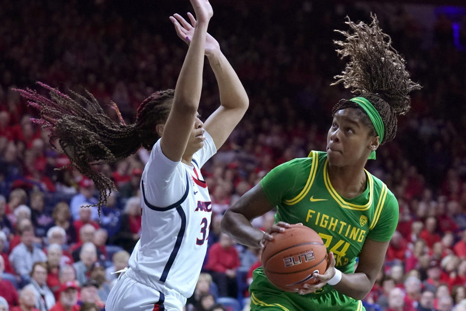 Oregon forward Ruthy Hebard (24) drives against Arizona center Semaj Smith during the first half of an NCAA college basketball game Sunday, Jan. 12, 2020, in Tucson, Ariz. (AP Photo/Rick Scuteri)