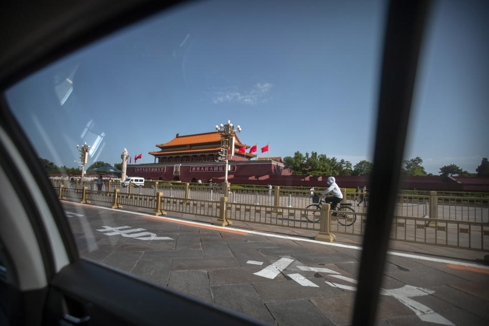 A cyclist wearing a face mask to protect against the new coronavirus rides past Tiananmen Gate near Tiananmen Square in Beijing, Thursday, June 4, 2020. China tightened controls over dissidents while pro-democracy activists in Hong Kong and elsewhere sought ways to mark the 31st anniversary Thursday of the crushing of the pro-democracy movement centered on Beijing's Tiananmen Square. (AP Photo/Mark Schiefelbein)