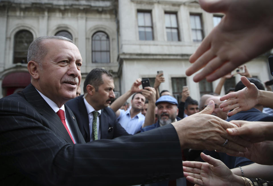 Turkish President Recep Tayyip Erdogan shakes hands with his supporters after Friday prayers, in Istanbul, Friday, Oct. 18, 2019. Erdogan says his country "cannot forget" an unusual letter that U.S. President Donald Trump sent him, but says the mutual "love and respect" between the leaders prevent him from keeping it on Turkey's agenda.(Presidential Press Service via AP, Pool )