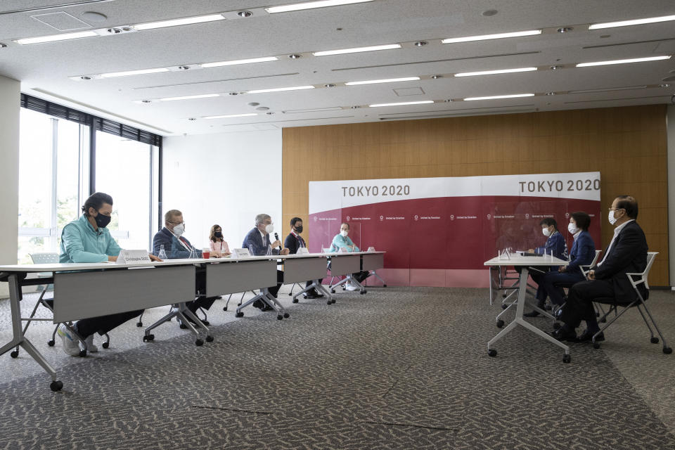 IOC President Thomas Bach, fourth from left, speaks to Tokyo 2020 President Seiko Hashimoto, second from right, during their meeting at the Tokyo 2020 Headquarters Tuesday, July 13, 2021 in Tokyo, Japan. (Takashi Aoyama/Pool Photo via AP)