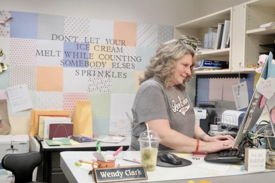 Wendy Clark keeps an eye on students coming in to the front desk as she manages work on her computer on April 22, 2024. She said she is "salty" about the closure of Ben Eielson at the end of the school year. (Photo by Claire Stremple/Alaska Beacon)