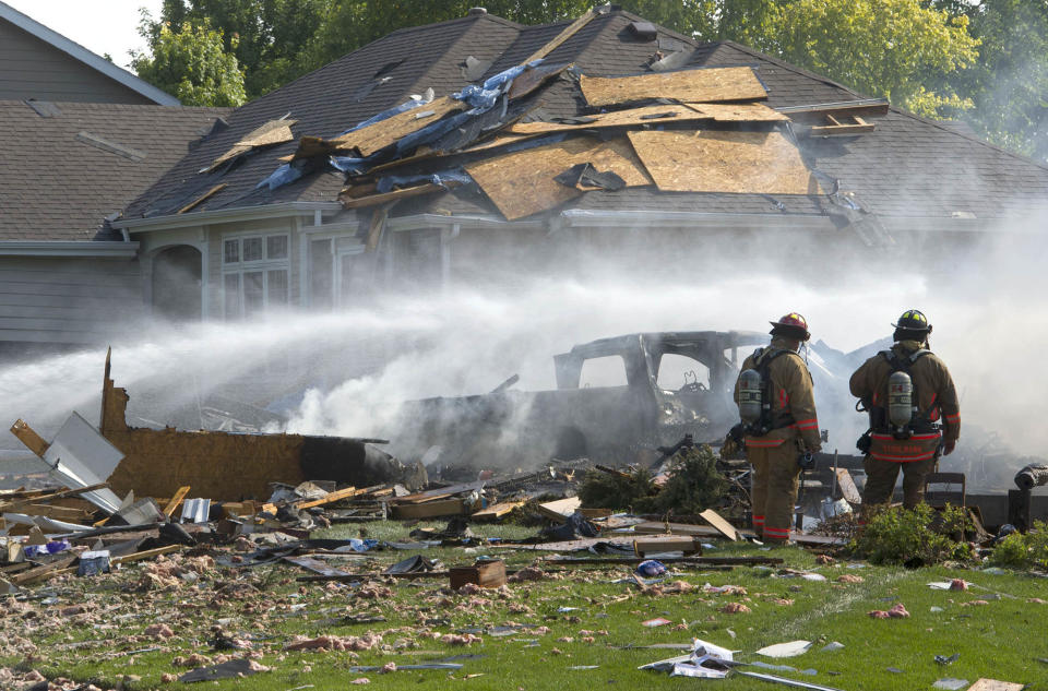 FILE - In this Aug. 14, 2017 file photo, firefighters walk through rubble following a house explosion in Lincoln, Neb. A man fatally injured in a natural gas explosion at the house in Lincoln intentionally caused the blast so he could kill his wife, Lincoln police said Thursday, Oct. 11, 2018. (Amber Baesler /Lincoln Journal Star via AP, File)