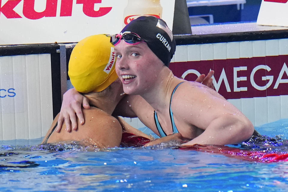 Claire Curzan of the United States ,right, embraces Iona Anderson of Australia at the end of the women's 50-meter backstroke final at the World Aquatics Championships in Doha, Qatar, Thursday, Feb. 15, 2024. (AP Photo/Hassan Ammar)