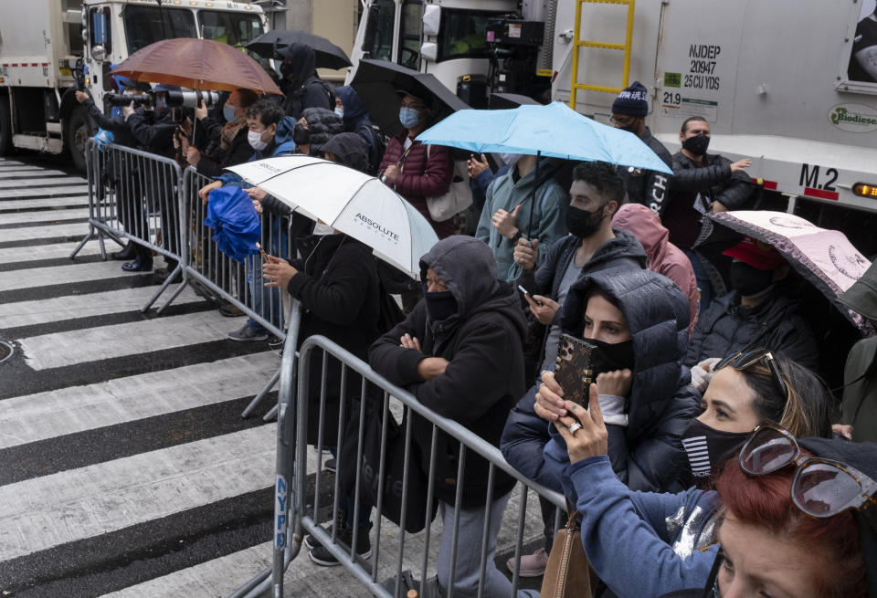 People watch the modified Macy's Thanksgiving Day Parade from about two blocks away in New York, Thursday, Nov. 26, 2020. Due to the pandemic, crowds of onlookers were not allowed to attend the annual parade. (AP Photo/Craig Ruttle)